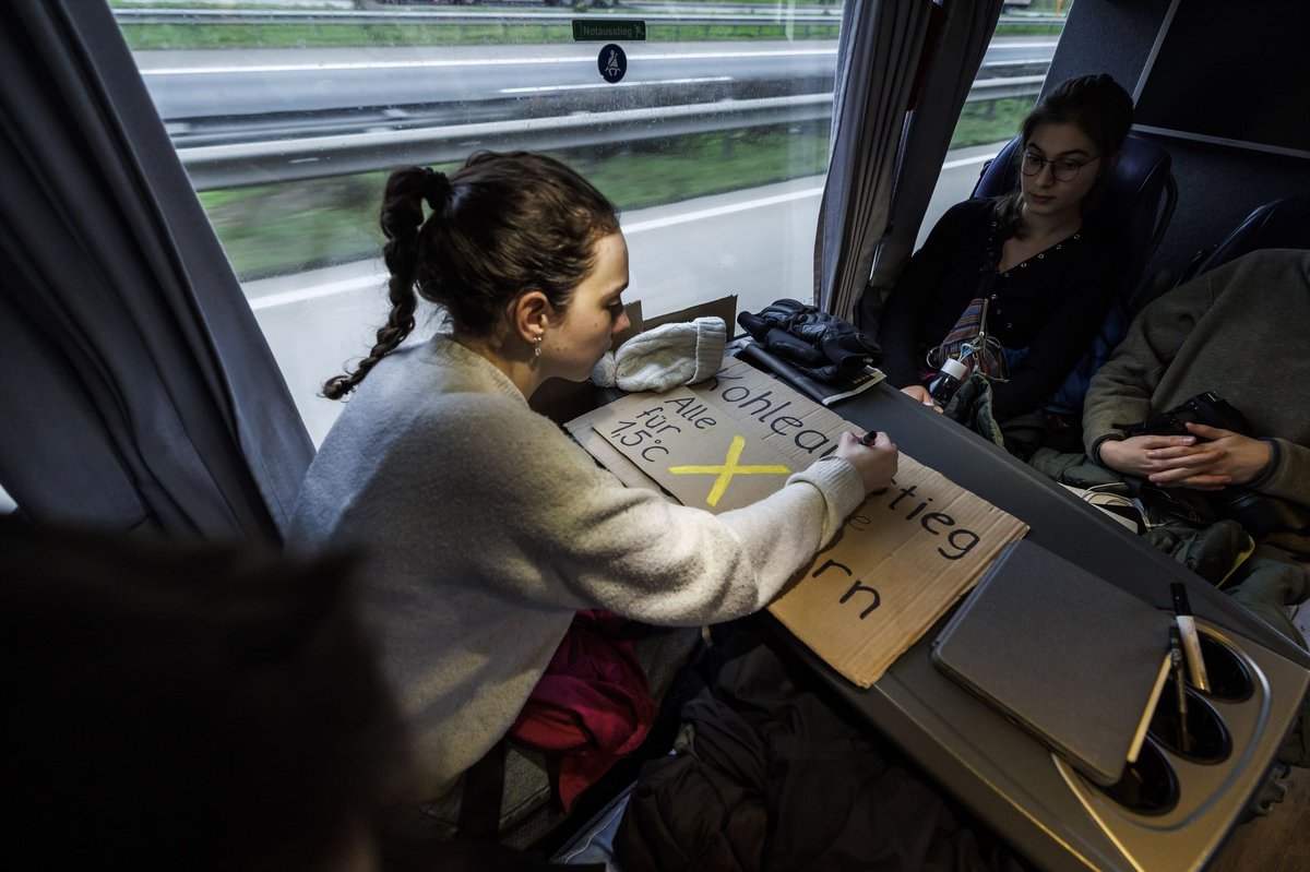 Vorbereitungen im Bus: Eine Demonstrantin arbeitet an ihrem Schild. 