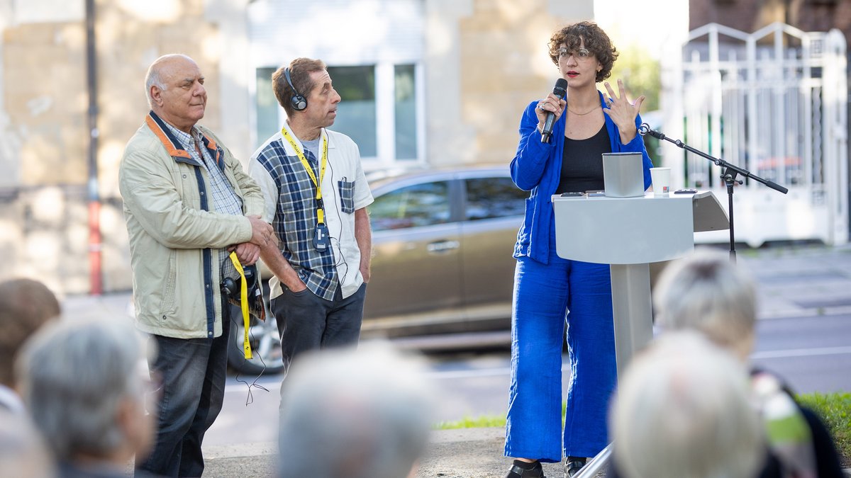 Howard Dancyger (mit Kopfhörer) und die Historikerin Josefine Geib bei der Einweihung des Shmuel-Dancyger-Platzes am 18. September 2025. Foto: Julian Rettig