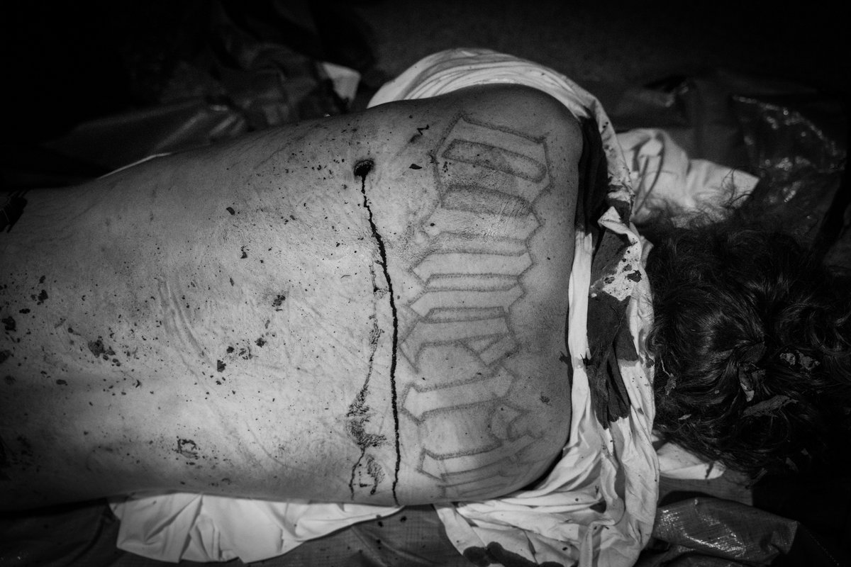 Aus der Serie "American Homicide": Ein Opfer liegt am Boden, während Ermittler und Spurensicherung versuchen, den Tathergang zu rekonstruieren. Das Tattoo des Opfers: "Muerta", was auf Spanisch "tot" bedeutet. Pleasant Grove, Texas, Juni 2022.