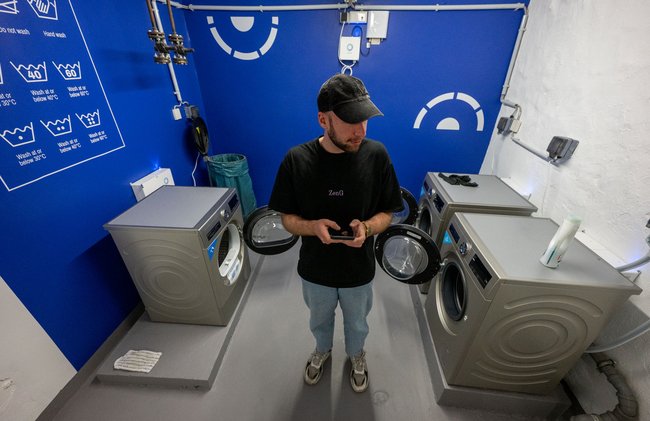 Lukas Walter in der neuen Waschküche seines Wohnheims – natürlich mit Handy. 