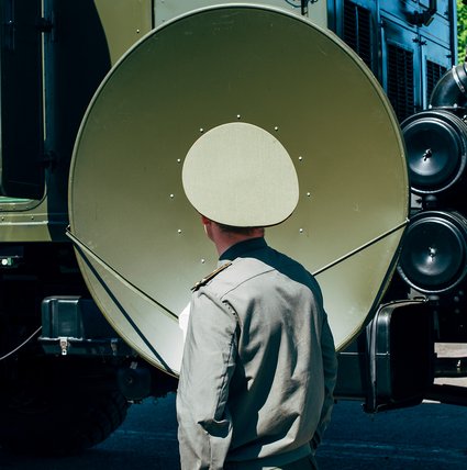 Ein belarussischer Offizier vor der Satellitenschüssel eines Multimediawagens. MILEX Expo, Minsk, Belarus 2017.