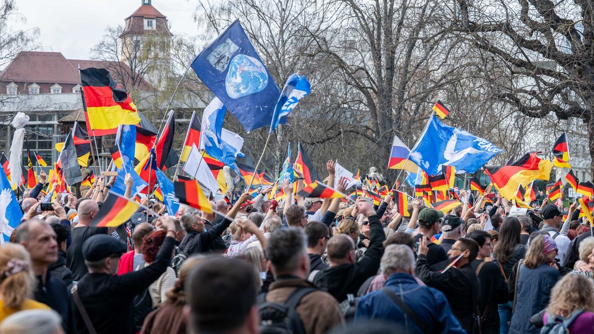 Friedenstauben im schwarz-rot-goldenen Fahnenmeer.