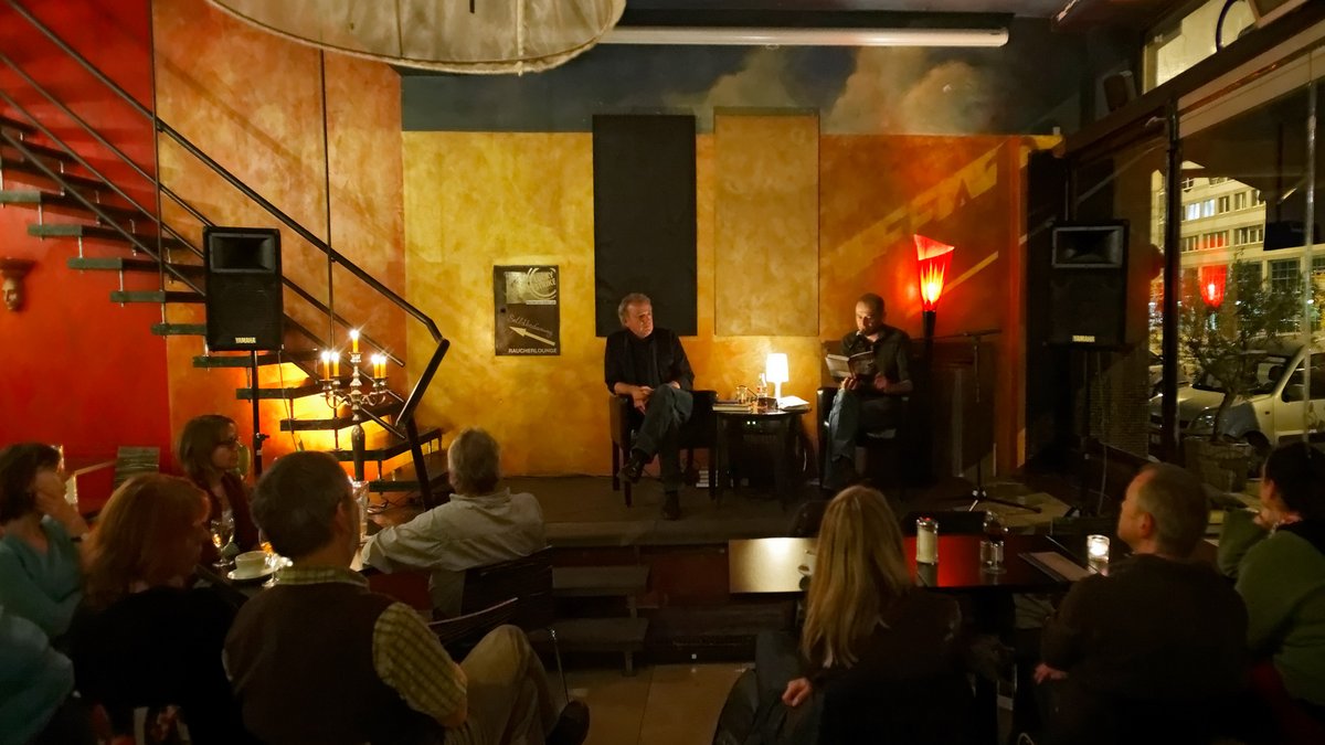 Unter Nachbarn: Kontext-Veranstaltungen gab es früher im Café Stella, das im Erdgeschoss untergebracht war – und 2015 schließen musste. Hier auf der Bühne, bei einer Lesung im Juli 2011, sitzen die ehemaligen Redakteure Rainer Nübel (links) und Sandro Mattioli. Foto: Joachim E. Röttgers