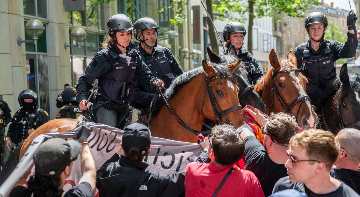 Mit Pferden wird die Demonstration zurückgedrängt. 