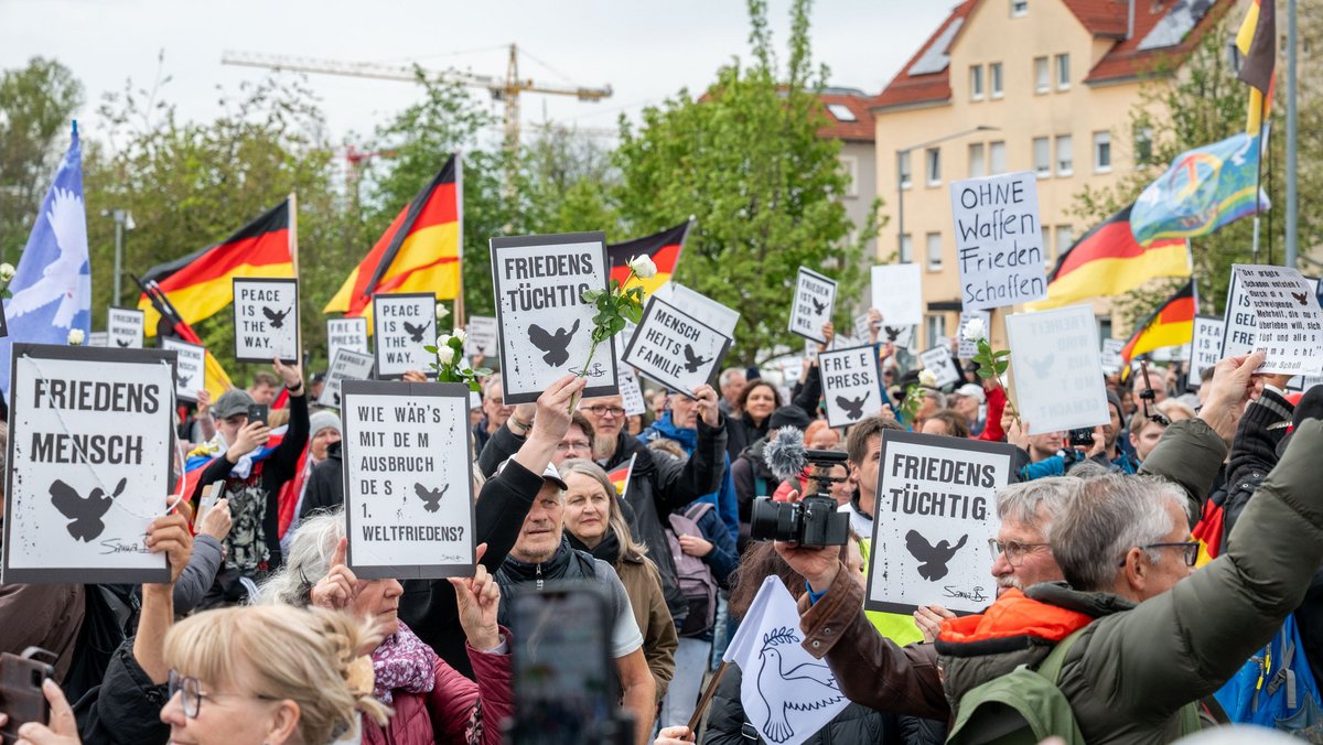 Auf Kommando strecken die "Gemeinsam für Deutschland"-Demonstrierenden ihre Plakate in die Höhe. Fotos: Jens Volle