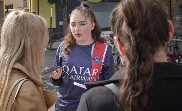 Phoebe fragt die Menschen auf der Straße, wie sehr sie die hohen Preise spüren.
