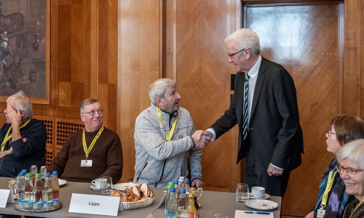 ... der alle mit Handschlag begrüßt (hier: Klaus Lipps). Noch wird im Gobelin-Saal gelächelt...