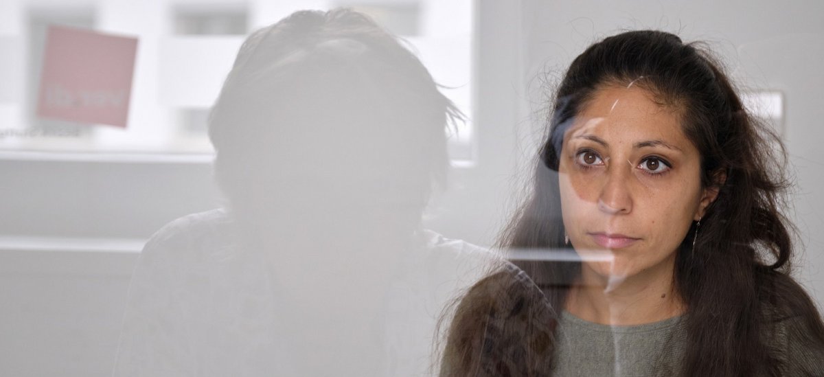 Durch die Glasscheibe: die Verdi-Sekretärin im Gespräch mit Kontext.