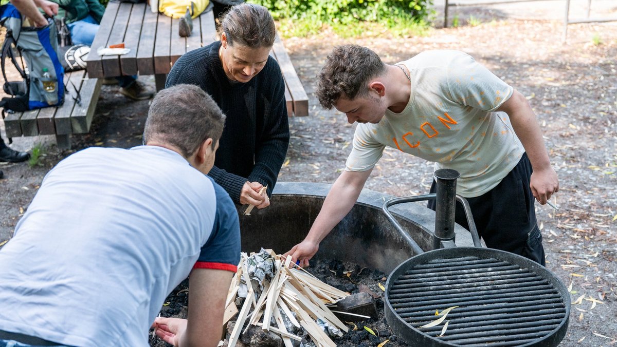 Grillprofis: Michele (rechts), Lennart (links) und Lehrerin Katrin Berthold machen Feuer.  Grillprofis: Michele (rechts), Lennart (links) und Lehrerin Katrin Berthold machen Feuer.