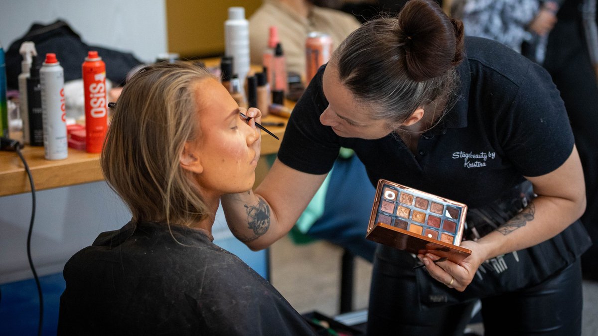 Nebenan geben die Visagist:innen ihr Bestes und sparen nicht mit Gold und Bronze.