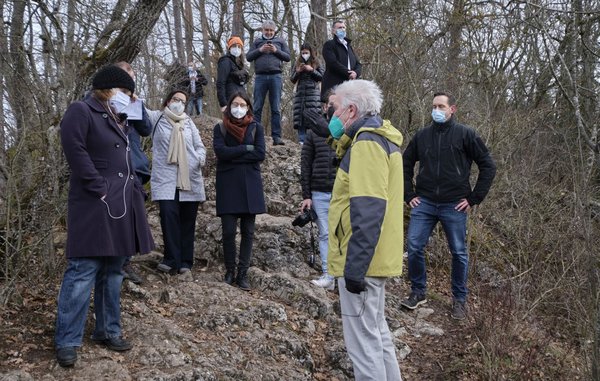 Umringt von JournalistInnen steigt Kretschmann auf den Amalienfelsen. 