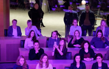 ... und die Besucherinnen im Plenarsaal in lila Licht getaucht.