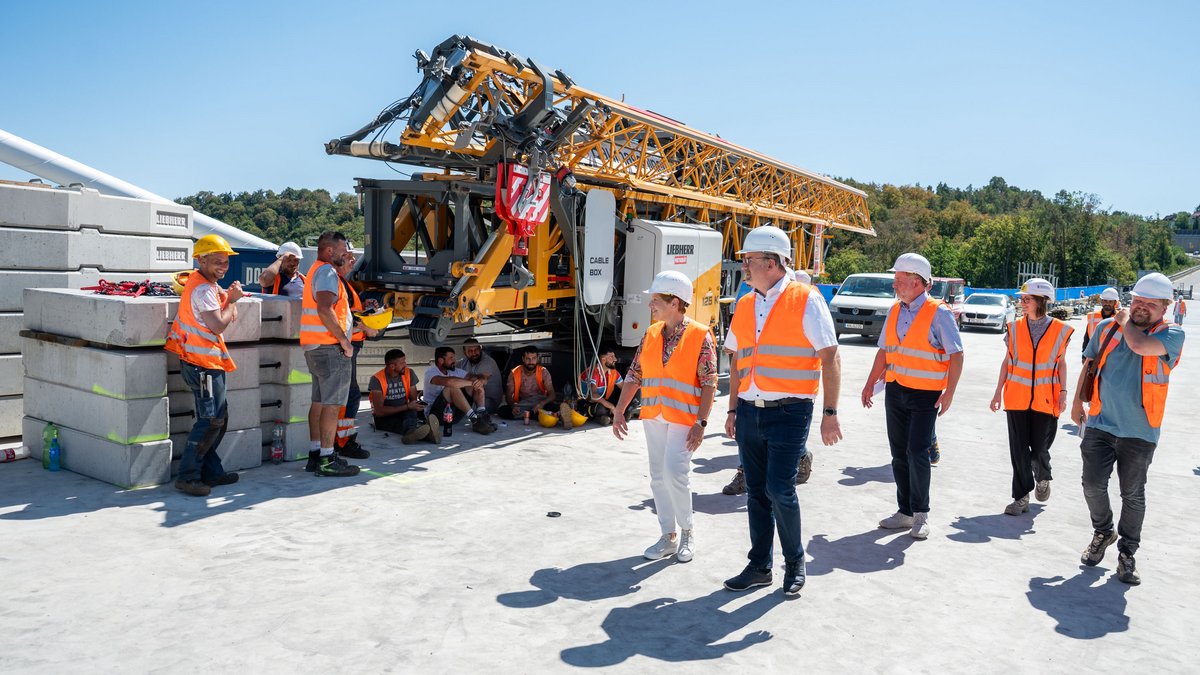Während die Ministerin die Brücke besichtigt, rasten die Arbeiter im raren Schatten.