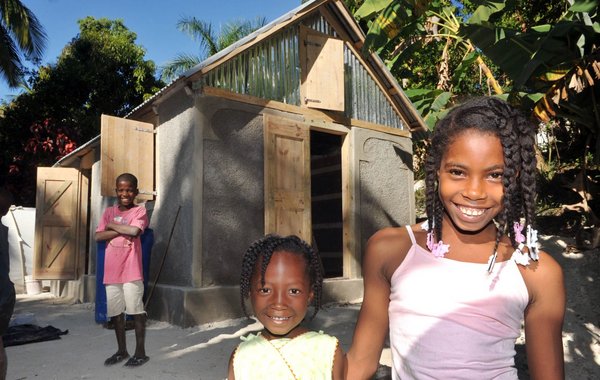 Ein Jahr nach dem Erdbeben: Freude über ein von der Diakonie erbautes Haus in Begin, Bezirk Bainet. Foto: Diakonie Katastrophenhilfe/Thomas Lohnes