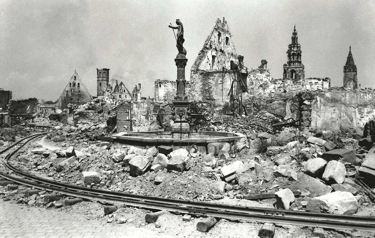 dokumentierte Bothner zerstörte Städte im Südwesten. Hier Heilbronn 1946, Blick auf den Fleinertor-Brunnen mit der Kilianskirche im Hintergrund, im Vordergund eine Trümmerbahn, wie sie in vielen Städten zum Einsatz kam.