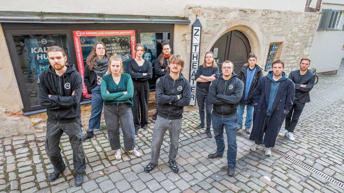 Mitarbeitende des Zimmertheaters. Um zu zeigen, was droht, haben sie sich selbst vor die Tür gesetzt. Fotos: Jens Volle