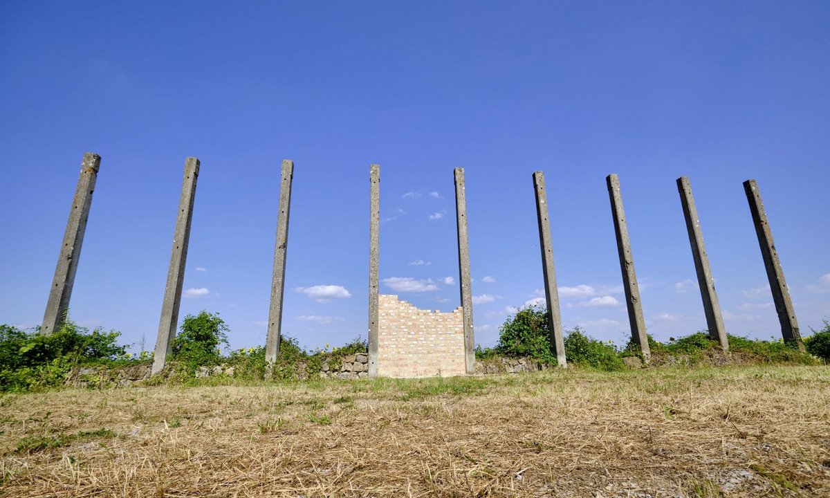 Die Gedenkwand für die ermordeten griechischen Zwangsarbeiter an der Ruine der Flugzeughalle ...