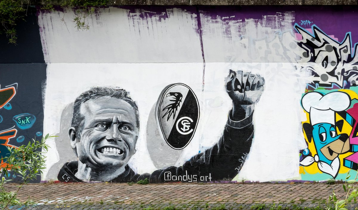 SC-Freiburg-Trainer Christian Streich auf einem Graffito an der Dreisam, 2014 zum Klassenerhalt des SC gemalt von Andreas Herre und Julian Mielke. Foto: Jörgens.mi, CC BY-SA 3.0, https://commons.wikimedia.org/w/index.php?curid=32541070