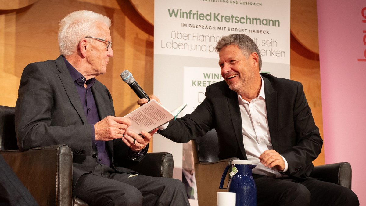 Winfried Kretschmann liest aus seinem neuem Büchlein, Parteifreund Robert Habeck macht den Mikrofonhalter. Foto: Julian Rettig