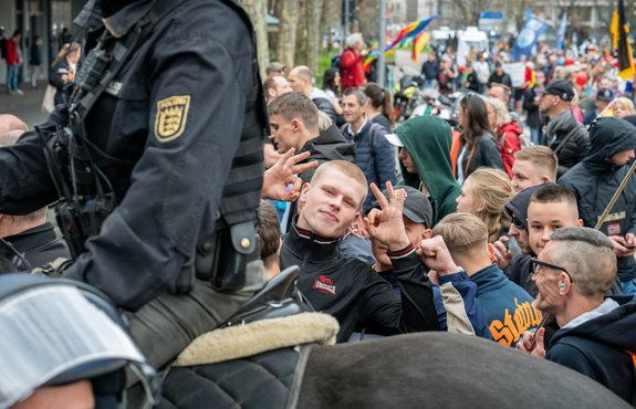 Stolz zeigt dieser junge Mann das White-Power-Zeichen in die Kamera.