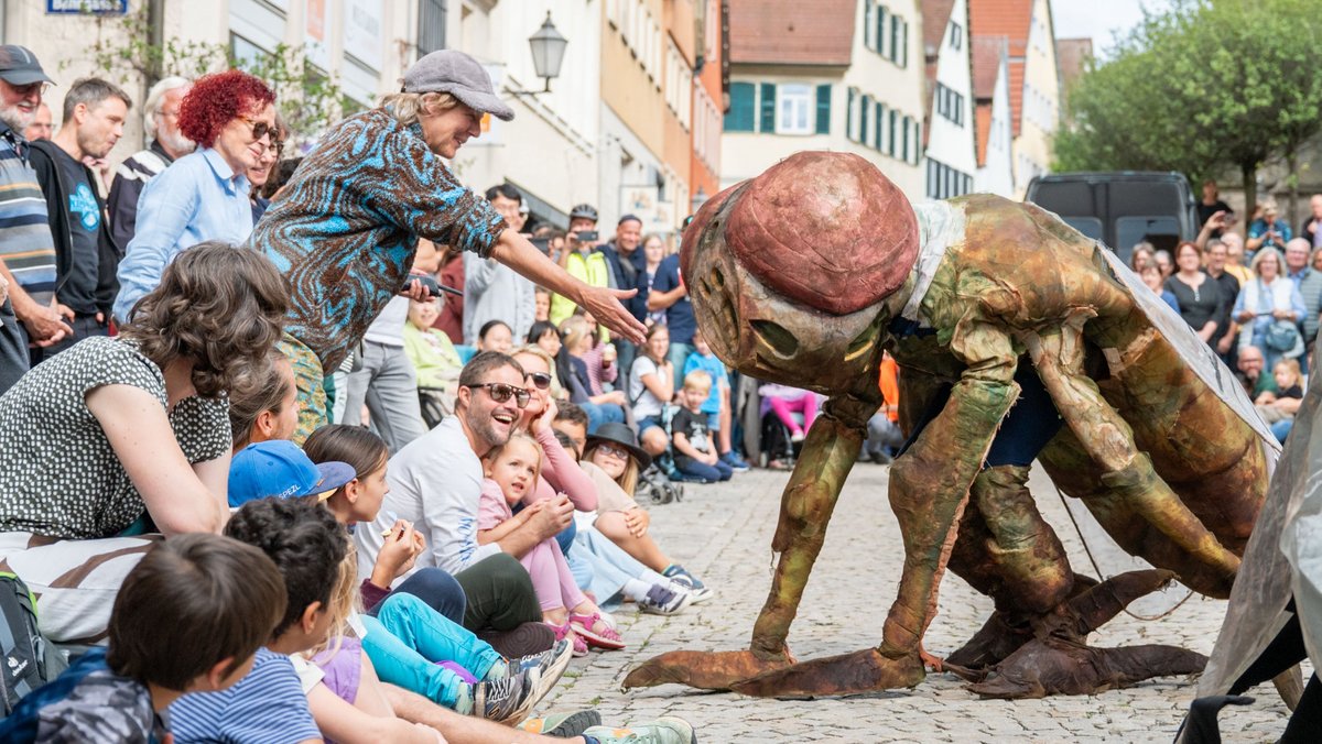 Beim Straßentheaterfestival in Schorndorf lässt Stefanie Oberhoff (graue Schildmütze) Fliegen durch die Altstadt wuseln.