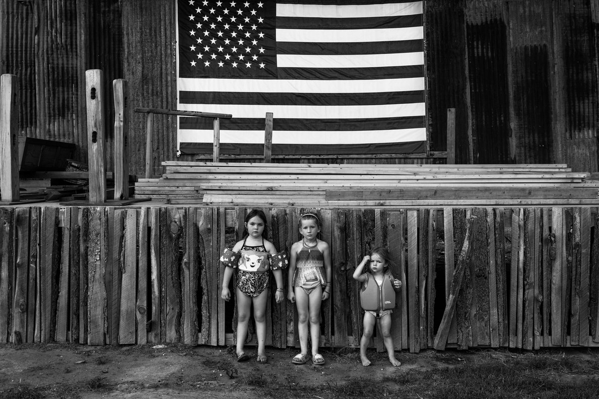 Aus Richard Sharums Serie "Spina Americana": Zwei Schwestern und eine Cousine vor dem Baden im familieneigenen Teich. Macksville, Kansas, Juni 2021. 