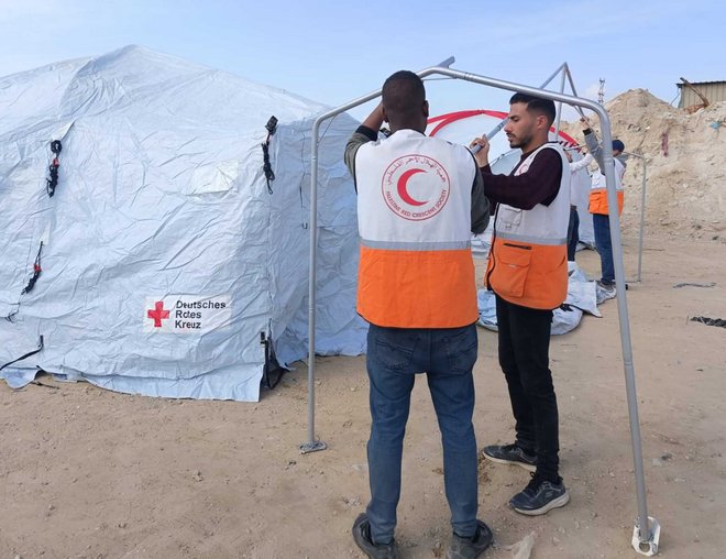Helfer des Palästinensischen Roten Halbmonds bauen Notunterkünfte aus Zeltplanen auf. Foto: Sabine Pompey, DRK