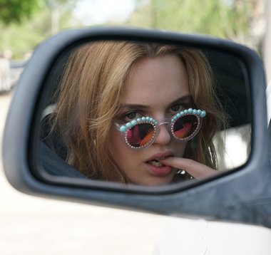 Protagonistin Lily fummelt an ihrem Smartphone oder kaut auf ihrem Finger herum.