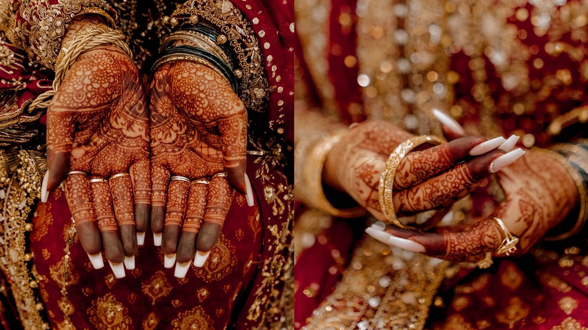 Hände einer Braut mit traditioneller Henna-Bemalung und Goldschmuck.