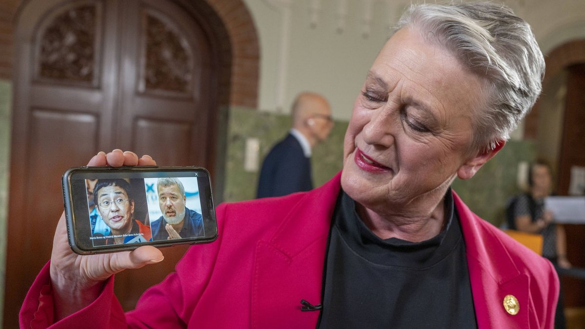 Die Nobelkomitee-Vorsitzende Berit Reiss-Andersen hält Bilder von Maria Ressa und Dmitri Muratow in die Kameras. Foto: Heiko Junge / NTB