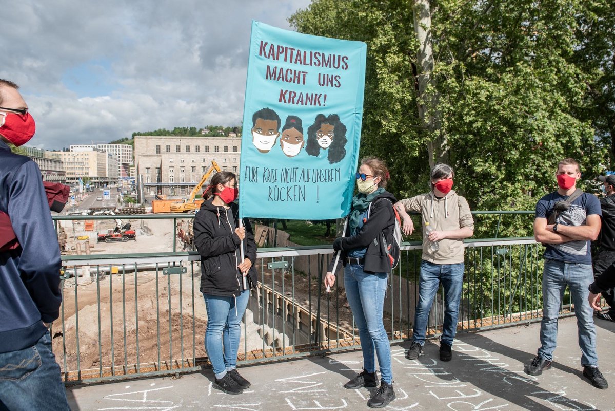 Einige der revolutionären Schilder und ihre Träger sind am Vormittag schon auf dem Ferdinand-Leitner-Steg am Rand der Stuttgart-21-Baustelle, ...