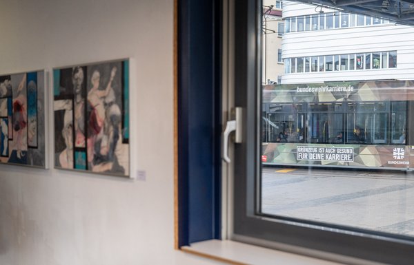 Drinnen Anti-Kriegskunst, draußen fährt Bundeswehrwerbung vorbei.