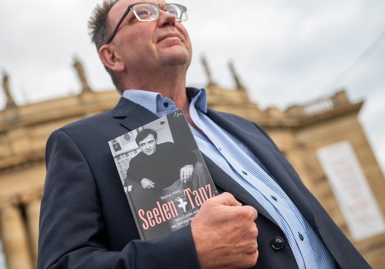 Thomas Aders mit seinem Cranko-Roman vor der Oper. Foto: Jens Volle