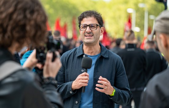 Linken-Vorsitzender Luigi Pantisano spricht am Auto-Aktionstag für die Kamera. Foto: Jens Volle