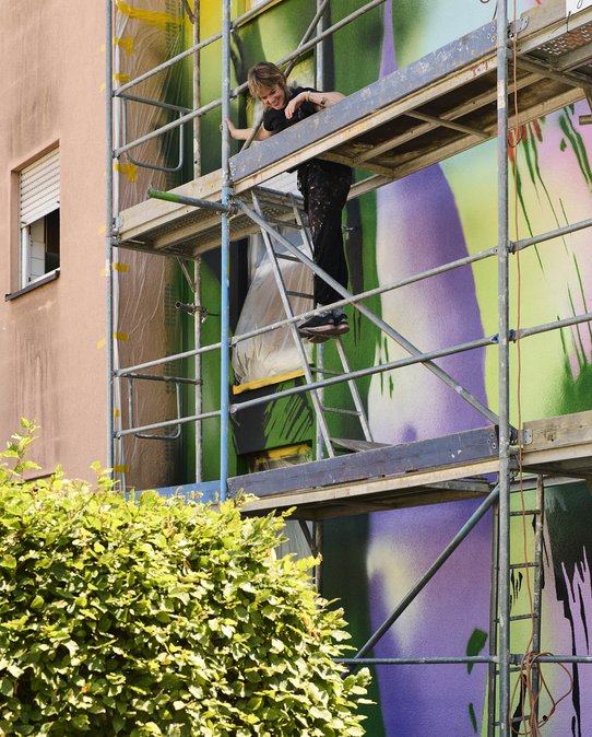 Julia Benz vor ihrem Mural an der Talstraße. Foto: Sven Weber