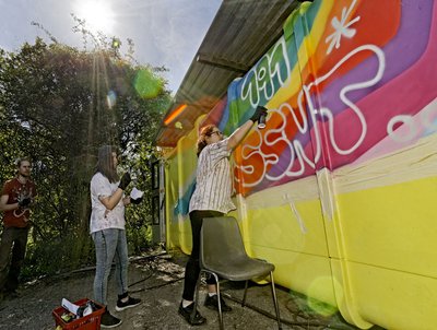 Mädchen aus dem Viertel besprühen einen Container, der später zur mobilen Küche werden soll.
