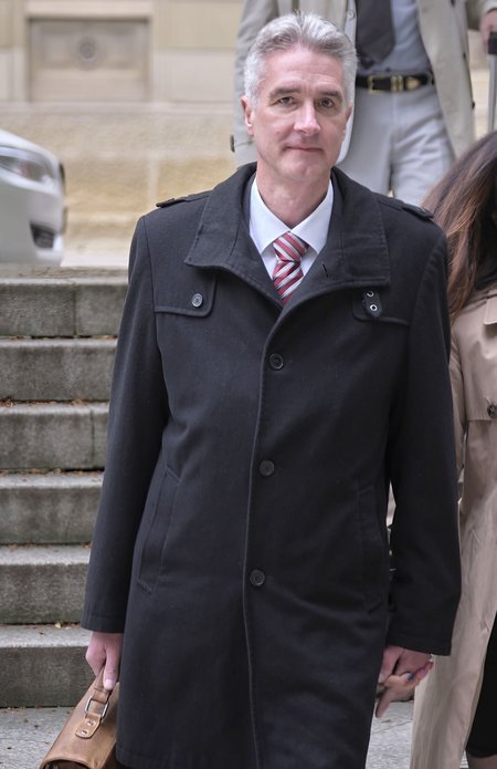 Der Angeklagte betritt das Gerichtsgebäude in Begleitung seiner Ehefrau.