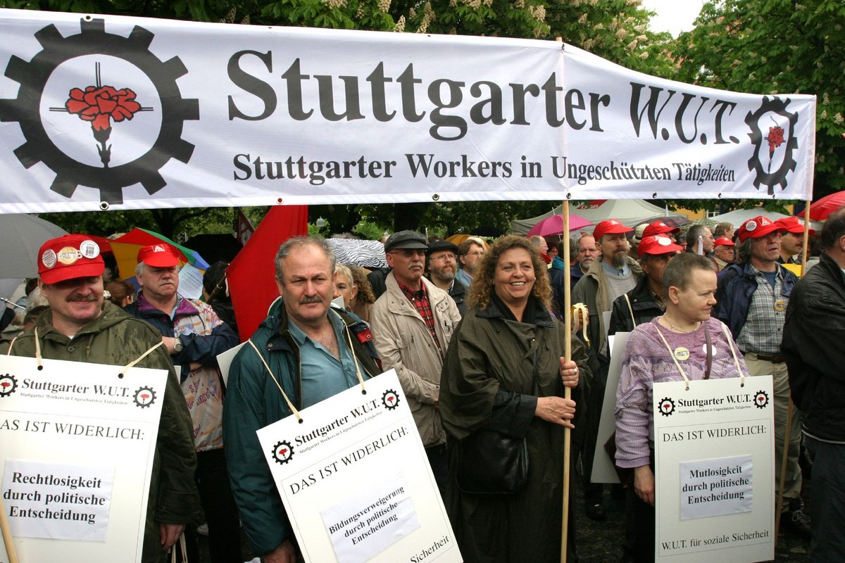 Unter der Theologenfahne wird am 1. Mai 2004 demonstriert, dem Tag der Arbeit, die sie nicht haben.