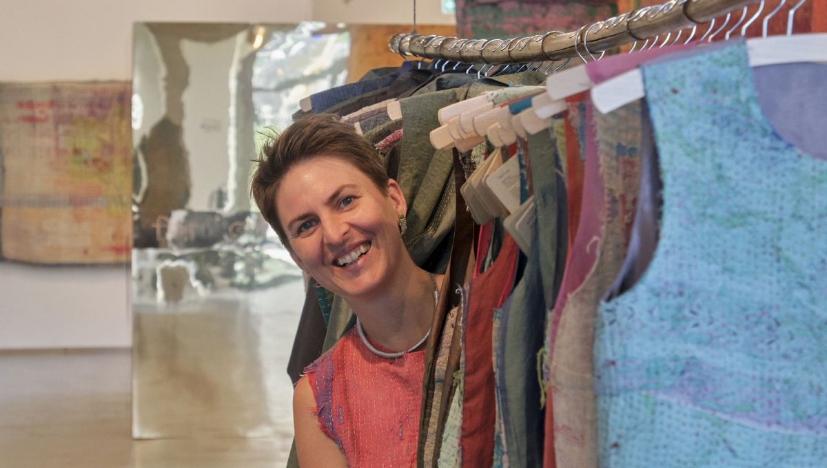 Die Initiatorin von "Dipdii Textiles", Anna Heringer, zwischen den Exponaten der Schau "Kleider machen Orte". Foto: Joachim E. Röttgers