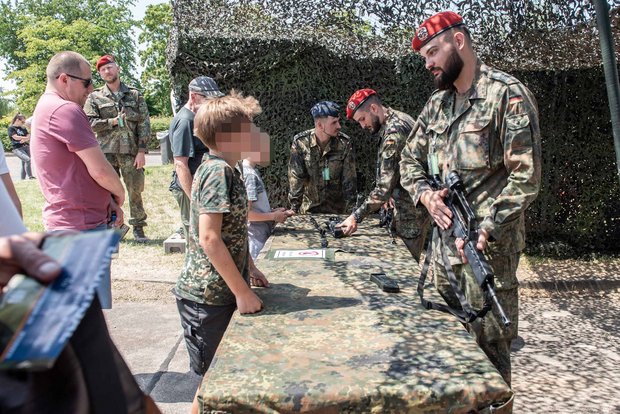Präsentiert das Gewehr: An einem Stand etwas abseits führt ein Soldat seine Schusswaffe vor. 