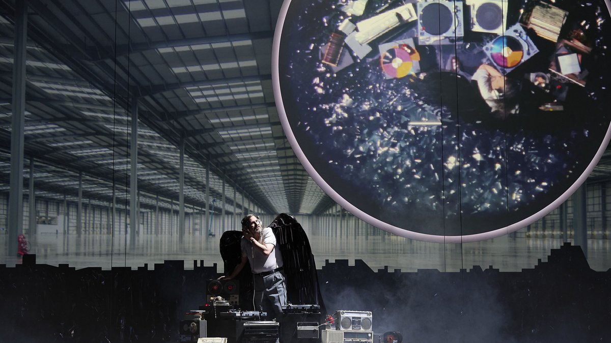 ein ungeheurer DJ – vor einer leeren Werkshalle
