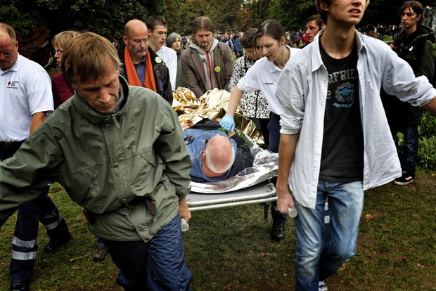 Demonstranten tragen einen Verletzten aus dem Park. Foto: Martin Storz