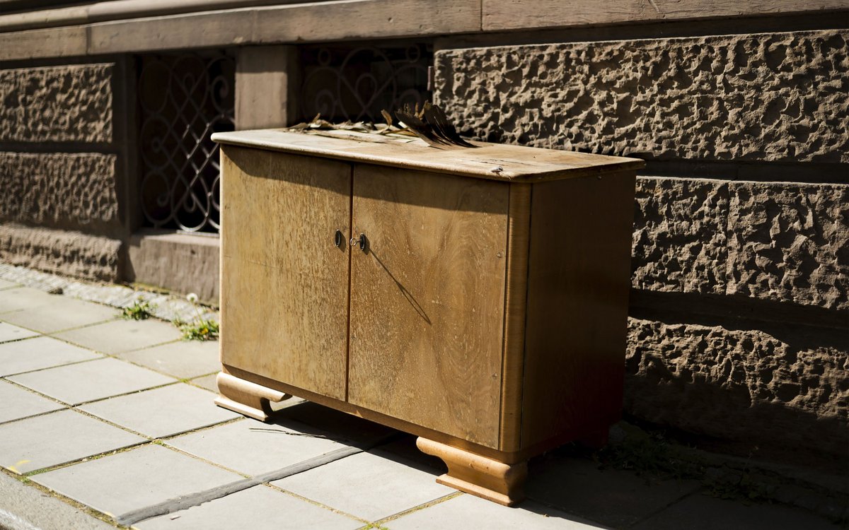 Was hat die Kommode einmal verborgen, die am Ende ihres Lebens am Straßenrand wartet und den Schlüssel in die Sonne reckt? 