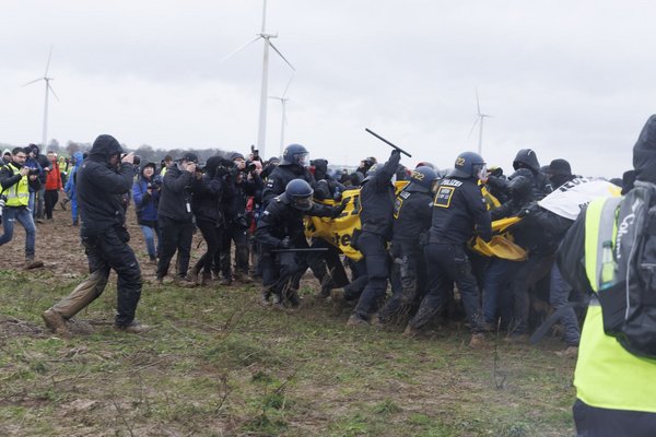 Aktivist:innen versuchen, eine Polizeikette zu durchbrechen. Aktivist:innen versuchen, eine Polizeikette zu durchbrechen.