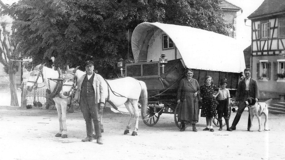 Jenische Familie mit Planwagen. Große Hunde dienten dem Schutz – und dem Fangen von Igeln, die als Sonntagsbraten zubereitet wurden. Deshalb findet sich der Igel auch im Logo des Zentralrats wieder. Quelle: Archiv Jakob Kronenwetter