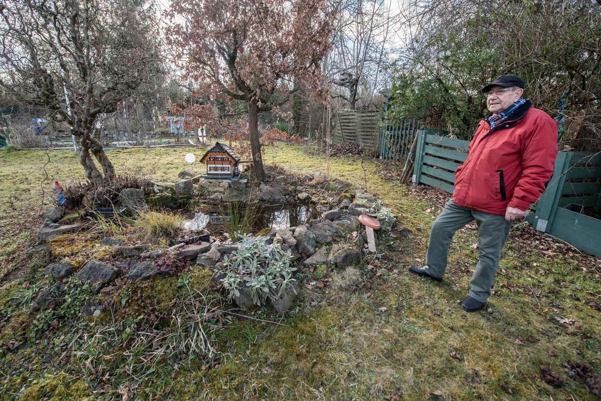 Einer der Kleingärtner, Norbert Gunkel, mit seinem Teich und dem selbstgezimmerten Schwarzwaldhaus.