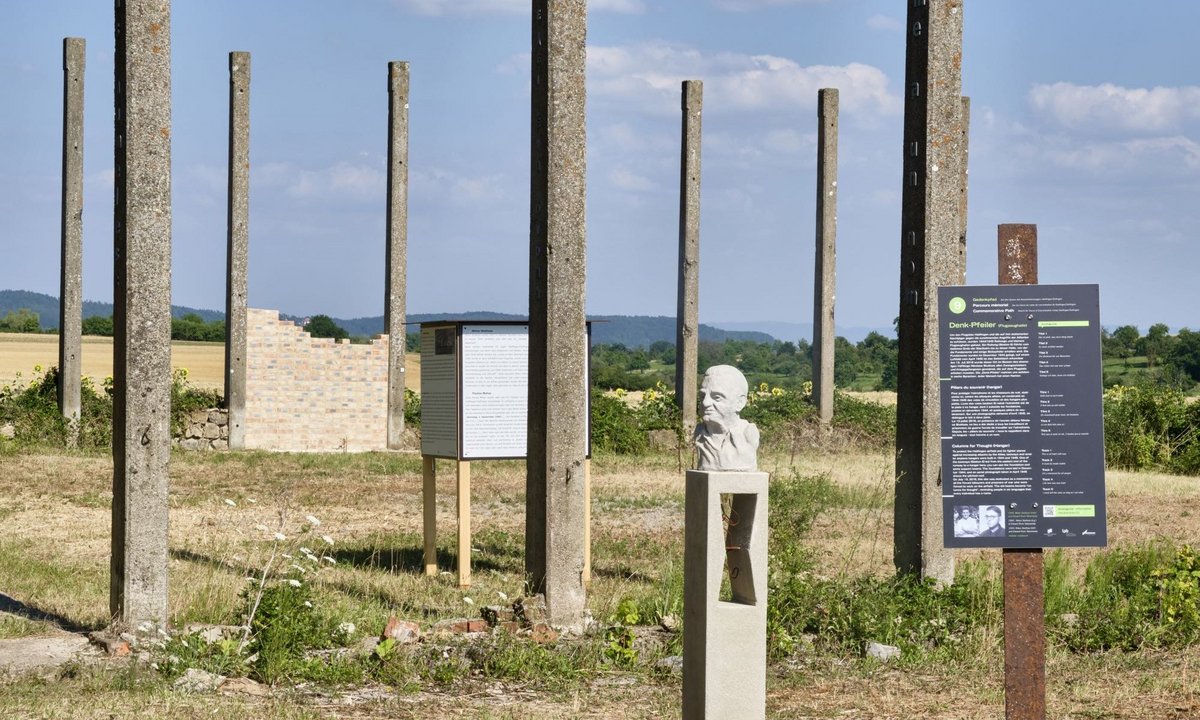 Eine Station auf dem Gedenkpfad zum Konzentrationslager Hailfingen/Tailfingen: Mahnmal und Gedenkwand für die ermordeten griechischen Zwangsarbeiter an der Ruine der Flugzeughalle. Weitere Stationen mit Klick auf den Pfeil.