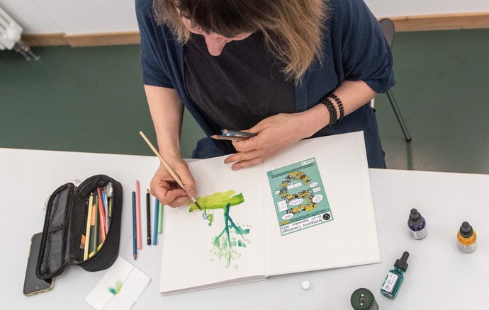 Auch beim Signieren ihrer Bücher greift Yelin zu Pinsel und Aquarellfarbe.