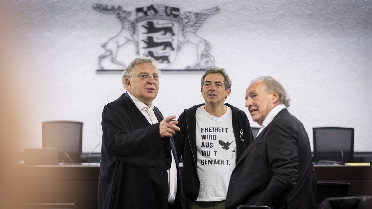 Michael Ballweg (Mitte) mit Anwälten (links Reinhard Löffler) beim Prozessauftakt im Landgericht Stuttgart, Oktober 2024. Foto: Julian Rettig