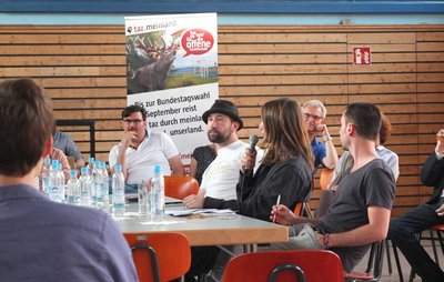 Kontext-Redakteur Minh Schredle (am Mikrofon) im Gespräch. Foto: Kontext